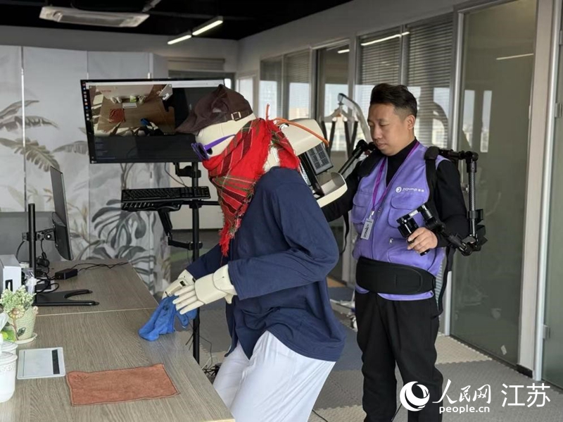 在工作人员操控下，机器人练习抓、取、放等技能。人民网记者 马晓波摄